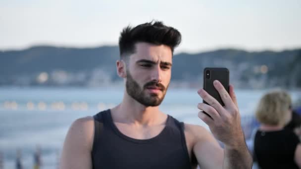 Hombre guapo haciendo videochat en el mar — Vídeo de stock