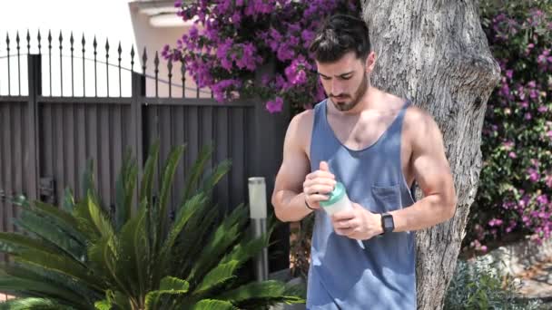 Mannen dricker protein shaker från blender — Stockvideo