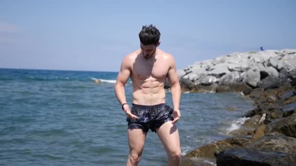 Junger Mann am Strand, schwimmt im Meer — Stockvideo