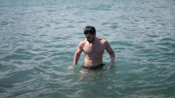 Young man at the beach, swimming in the sea — Stock Video