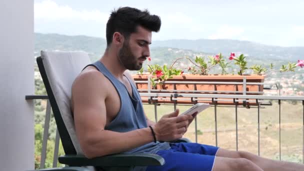 Mann arbeitet auf Balkon am Tablet-Computer — Stockvideo