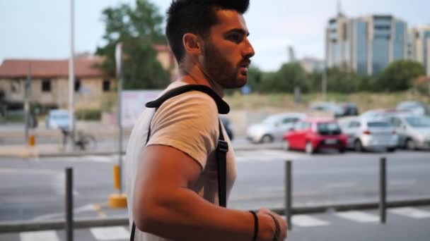 Hombre joven caminando al aire libre con mochila — Vídeo de stock