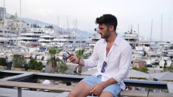 Attractive athletic young man on seaside promenade — Stock Video