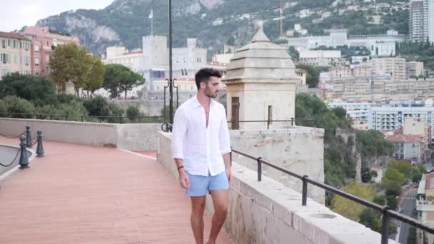 魅力的なフィット運動の若い男バルコニー ボードウォークにフランスのリビエラのモンテカルロ モナコの上の白いシャツを着て — ストック動画