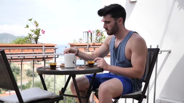 Young man drinking espreso coffee on terrace — Stock Video