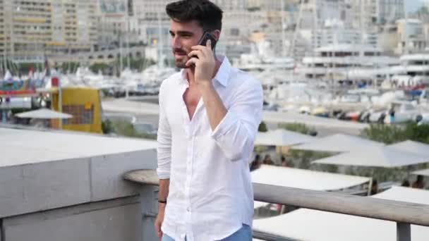 Jonge man in Monaco praten op mobiele telefoon — Stockvideo