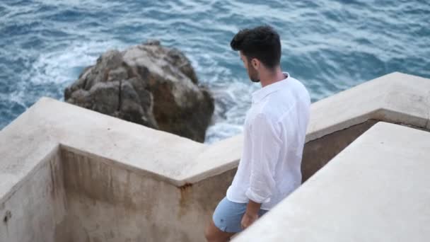 Attractive athletic young man looking at sea — Stock Video