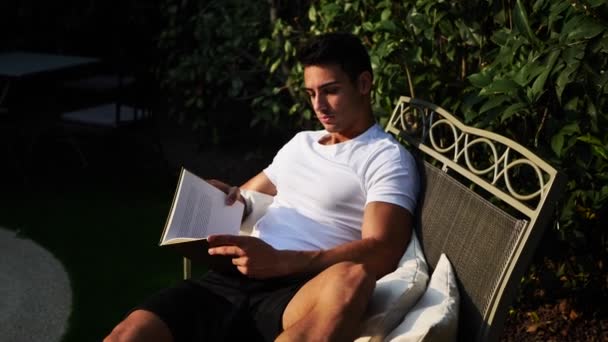 Hombre estudiante lectura libro al aire libre — Vídeos de Stock