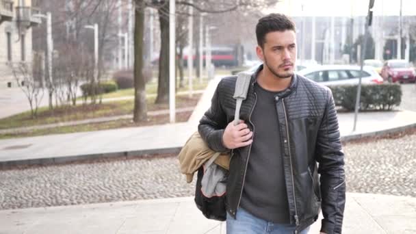 Handsome young man walking in city with backpack — Stock Video