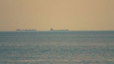 Gün batımında konteyner gemisi limana girmek için bekliyor.