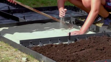 Duyusal bahçede farklı malzemelerden yapılmış bir yol inşa eden küçük çocuklar. Ahşap, saman, kaya, toprak ve kum dokusu. Çiçek bahçesinde yürüyen insanlar. Yakın plan.