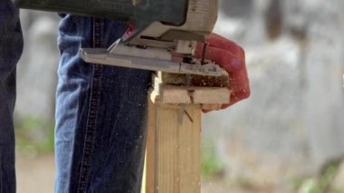 Kurulum için mükemmel biçimi kesmek için endüstriyel araç kullanan kişi tahta panelleri kesiyor