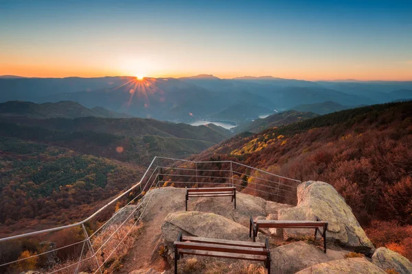 美丽的全景天际线秋季景观与山顶长凳和五颜六色的日出以上的秋天森林在罗多彼山 保加利亚 — 图库照片