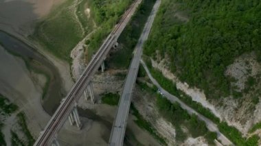 Kuruyan bir barajı ve baharda üzerinden geçen köprüleri olan pitoresk bir vadi üzerindeki hava aracı uçuşu, Bulgaristan 'ın Tzonevo barajı..