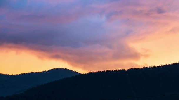 カラフルな夕日の空と山の峰の上に高速移動燃えるような赤い雲と時間の経過 — ストック動画