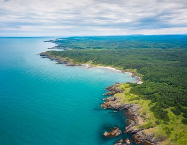 Bulgaristan 'ın güneyindeki Karadeniz kıyısındaki kayalar ve yeşil sık ormanlarla çevrili vahşi plajların hava panoramik manzarası.