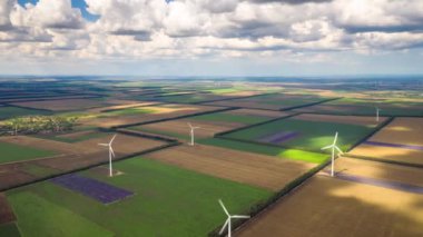 Yaz tarlaları boyunca rüzgar türbinlerinin üzerindeki aşırı kayma. Temiz ve yenilenebilir rüzgar enerjisi çiftliği hareket halinde. Yeşil enerji, sürdürülebilir alternatif elektrik, kirlilik ortamı yok