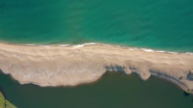 Bir tarafında deniz dalgaları, diğer tarafında ise denize dökülen bir nehrin suları, Bulgaristan 'ın Karadeniz kıyısındaki Veleka Nehri' nin ağzı ile çevrili güzel kumlu bir sahilin üzerindeki video.