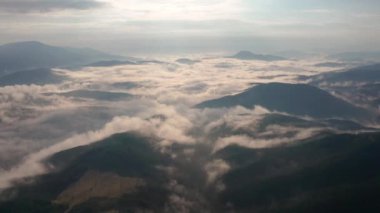 Alçak bulutlar ve sabah sisleri üzerinden insansız hava aracı uçuşu güneş doğarken dağları kapladı, Bulgaristan 'daki Rodop Dağları