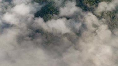 Alçak bulutlar ve sabah sisleri üzerinden insansız hava aracı uçuşu güneş doğarken dağları kapladı, Bulgaristan 'daki Rodop Dağları