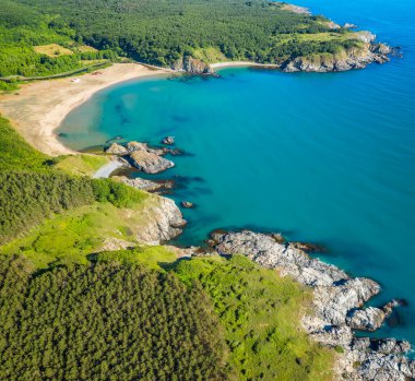Bulgaristan 'ın güneyindeki Karadeniz kıyısındaki kayalar ve yeşil sık ormanlarla çevrili vahşi plajın havadan panoramik manzarası