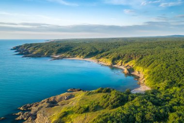 Bulgaristan 'ın güneyindeki Karadeniz kıyısındaki kum plajları, kayalar ve yeşil ormanların hava panoramik manzarası.