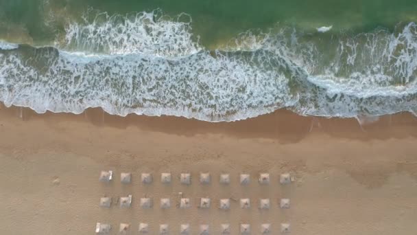 絵のように美しい海の波 黒海沿岸 ブルガリアの近くのわらの日影とサンベッド付きの空の美しい砂浜の上のビデオ — ストック動画