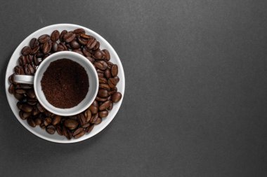 bir tabak ile kahve bitkisinden meyve ile taze çekilmiş kavrulmuş kahve çekirdekleri ile bir fincan.