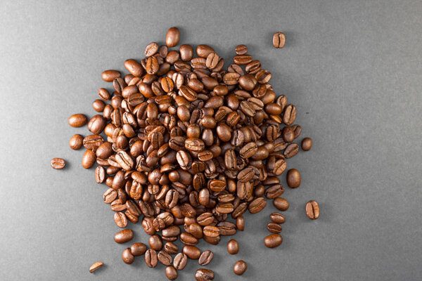 Freshly ground coffee beans roasted with fruits of coffee plant, full of grains, on black background of the image.