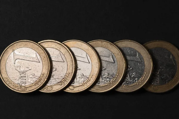 Некоторые монеты евро, лежащие друг на друге на матовом черном фоне . — стоковое фото
