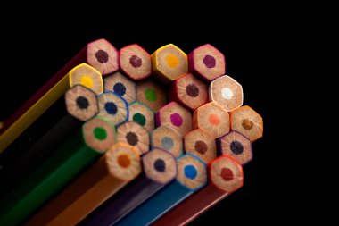 Ahşap kalemler tüm renklerde kalemlerin tabanında görülür. Renkli kalemler yığılmış. Siyah bir arka planla. Renk. Okula geri dön, eğitim.