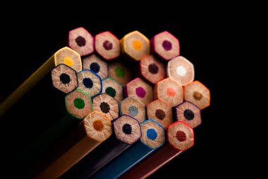 Ahşap kalemler tüm renklerde kalemlerin tabanında görülür. Renkli kalemler yığılmış. Siyah bir arka planla. Renk. Okula geri dön, eğitim.