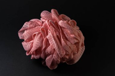 Siyah bir arka plan üzerinde, bir duş süngeri yerleştirilir ve uzatılır, sunumun ortasında.