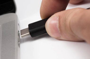 Usb kablosunu dizüstü bilgisayara takılan kişi.