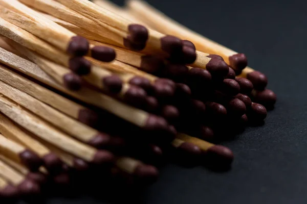 Match sticks accumulated on top of each other. Match sticks and black background.