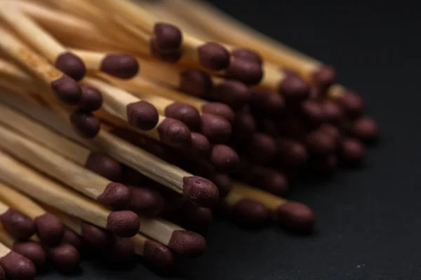 Match sticks accumulated on top of each other. Match sticks and black background.