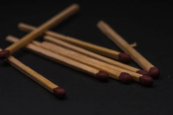 Match sticks accumulated on top of each other. Match sticks and black background.