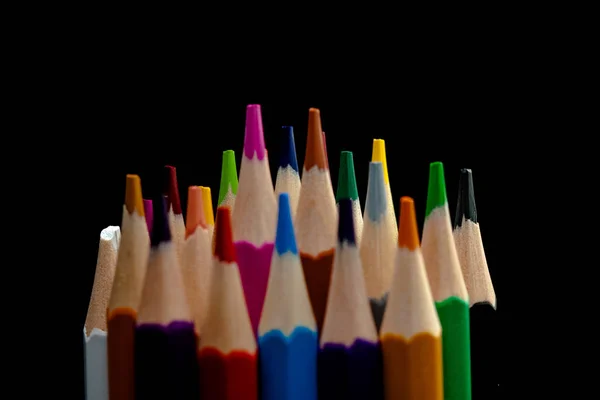 Dřevěné tužky ve všech barvách, viděných ze seznamu tužek. Barevné tužky navrstvené s černým pozadím. Barvy. Zpět do školy, vzdělání. — Stock fotografie