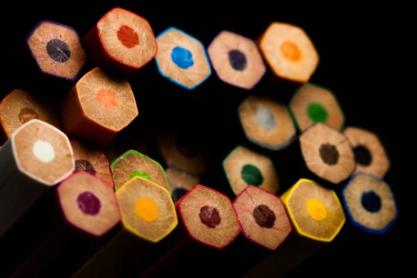 Houten potloden in alle kleuren gezien aan de basis van potloden. Gekleurde potloden gestapeld. Met een zwarte achtergrond. Kleuren. Terug naar school, onderwijs. — Stockfoto