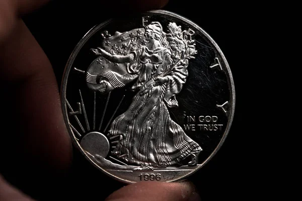 Mano de hombre sosteniendo una moneda americana de plata, primer plano de una moneda de un cuarto de dólar aislada sobre negro. Bolsa, dólares . — Foto de Stock