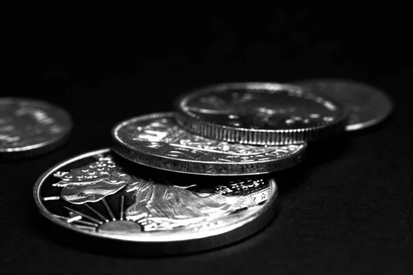 Birkaç sikke siyah bir arka plan üzerinde yığılmış. Beş sikke düzgün. Finansal.