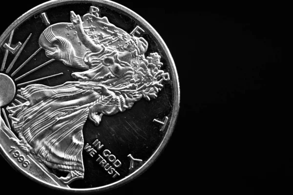 Adamın elinde gümüş bir Amerikan sikkesi var, çeyrek dolarlık sikkenin yakın çekimi siyahın üzerine izole edilmiş. Çanta, dolar.