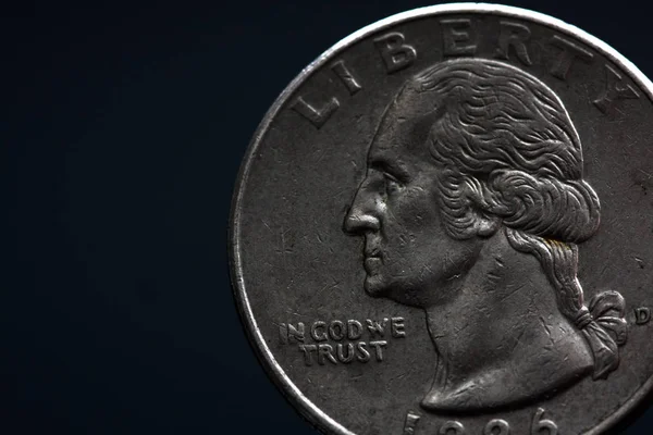 Adamın elinde gümüş bir Amerikan sikkesi var, çeyrek dolarlık sikkenin yakın çekimi siyahın üzerine izole edilmiş. Çanta, dolar.