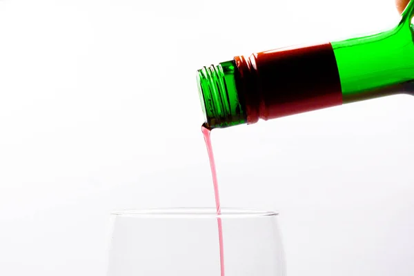 Töltelék pohár ital vörösbor, a zöld palack egy zöld palackot. Fehér alapon. — Stock Fotó