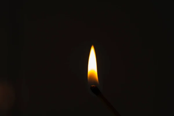 Match lit on a black background, bright fire on the matchstick. Fire in flames