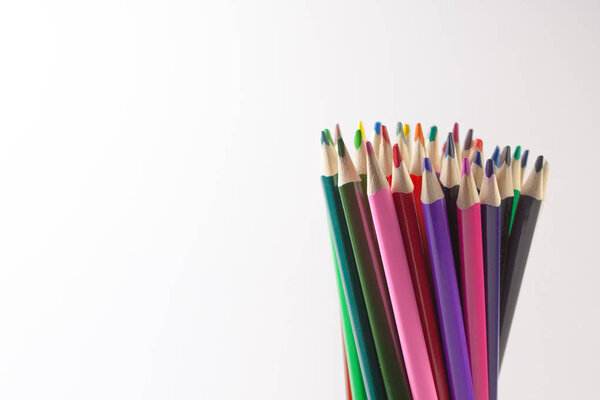 Группа цветных карандашей располагается вертикально на белом фоне. Возвращение в школу
.