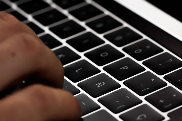 Manos en el teclado de una computadora, computadora en un fondo negro. Trabajos de oficina . — Foto de Stock