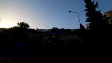 Birinci şahıs bakış açısı, bakış açısı, iç araç, ön camın arkasında, Malta'yı uçtan uca geçen kaputun perspektifi. Mavi bir gökyüzünde trafikte sürüş