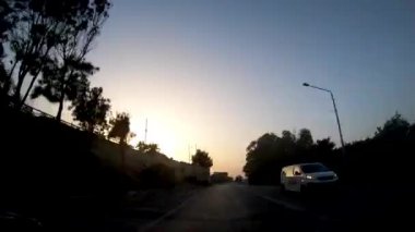 Birinci şahıs bakış açısı, bakış açısı, iç araç, ön camın arkasında, Malta'yı uçtan uca geçen kaputun perspektifi. Mavi bir gökyüzünde trafikte sürüş