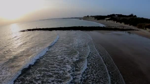 空中记录俯瞰地平线 海浪突破防波堤 地中海 日落在海滩上与五颜六色的天空 低潮在圣玛丽亚 基齐兹 安达卢西亚港 — 图库视频影像